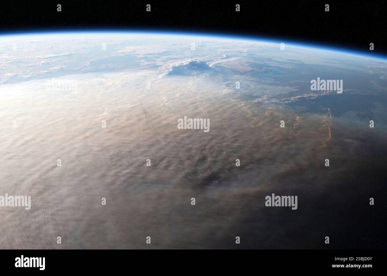 Un astronaute à bord de la Station spatiale internationale a capturé cette image de nuages de cendres au-dessus du Pacifique Sud le 16 janvier 2022. Quelques semaines avant l'acquisition de cette image, Hunga Tonga-Hunga Ha'apai, la partie supérieure d'un grand volcan sous-marin, a commencé à entrer en éruption. Les 13 et 14 janvier, de puissantes explosions ont envoyé des cendres dans la stratosphère. Puis, les explosions du 15 janvier ont lancé du matériel aussi haut que 40 kilomètres (25 miles) en altitude, couvrant les îles voisines de cendres et déclenchant des vagues de tsunami. Banque D'Images
