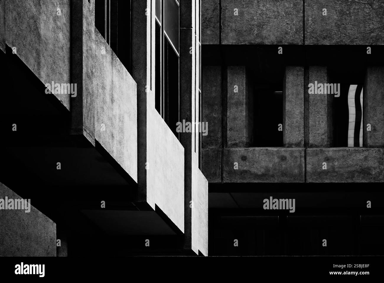 Photographie abstraite d'art noir et blanc à contraste élevé de deux bâtiments en béton construits dans un style architectural brutaliste. Diagonale et droite Banque D'Images