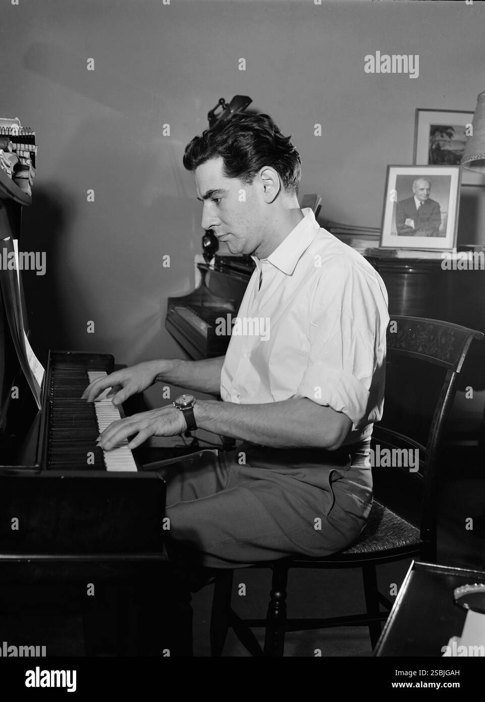 Portrait de Leonard Bernstein dans son appartement, New York, New York, entre 1946 et 1948. Bernstein (1918-1990) était un chef d'orchestre, compositeur, pianiste et humanitaire américain. Son œuvre la plus connue est la comédie musicale de Broadway West Side Story. Ses œuvres comprennent les symphonies, les Psaumes de Chichester, la sérénade d'après le Symposium de Platon, la partition originale du film sur le front de mer, et des œuvres de théâtre, y compris sur la ville, la ville merveilleuse, Candide, et MESSE. Banque D'Images