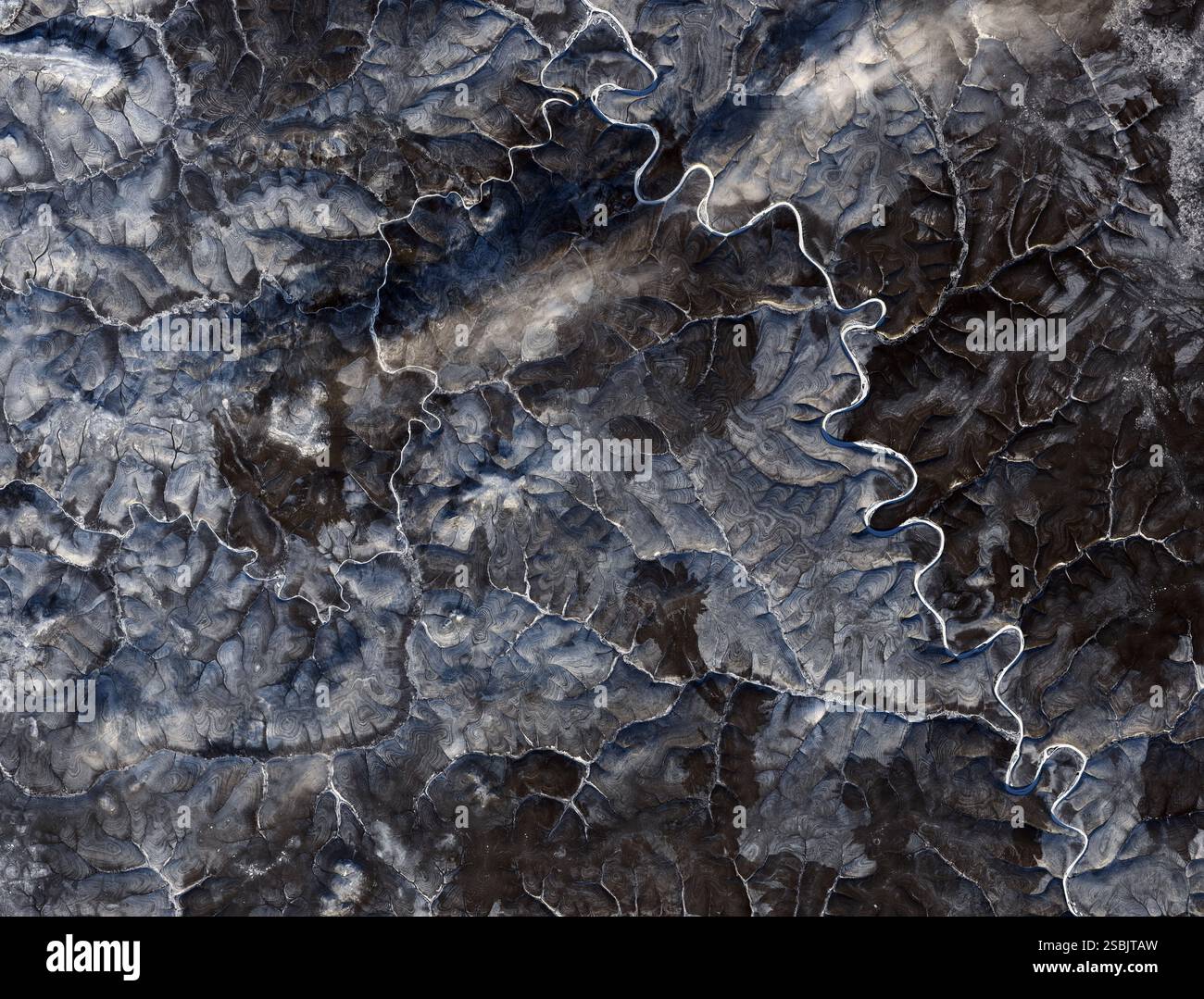 Image satellite d'une zone du plateau de Sibérie centrale septentrionale, Russie, en hiver. Cette région se trouve dans le cercle arctique, où les températures de l'air restent inférieures au point de congélation pendant une grande partie de l'année. Le paysage est recouvert de pergélisol qui peut s’étirer de dizaines à centaines de mètres sous la surface. Les cycles saisonniers de congélation et de décongélation peuvent créer des polygones, des cercles et d'autres types de « sols à motifs ». Image acquise par l'OPI (Operational Land Imager) sur Landsat 8, le 29 octobre 2020. Banque D'Images