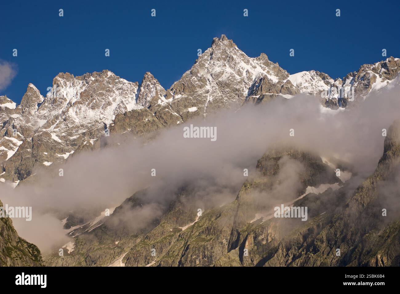 Le sommet de la montagne sur la photo est 'le Pelvoux' dans le massif des Écrins, France. Le Pelvoux est un sommet important situé dans les Alpes du Dauphiné, près du village d'Ailefroide en France. Il a plusieurs sommets, dont le plus haut est la pointe Puiseux, qui culmine à 3 946 mètres (12 946 pieds). L'aspect déchiqueté et accidenté du pic et du paysage environnant, combiné avec la vue depuis le pré de Madame Carle, sont révélateurs du Pelvoux. C'est l'un des sommets les plus reconnus de la région des Écrins. Banque D'Images