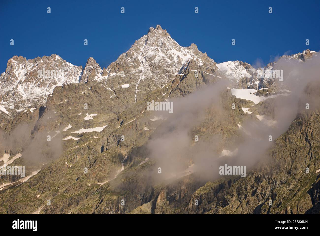 Le sommet de la montagne sur la photo est 'le Pelvoux' dans le massif des Écrins, France. Le Pelvoux est un sommet important situé dans les Alpes du Dauphiné, près du village d'Ailefroide en France. Il a plusieurs sommets, dont le plus haut est la pointe Puiseux, qui culmine à 3 946 mètres (12 946 pieds). L'aspect déchiqueté et accidenté du pic et du paysage environnant, combiné avec la vue depuis le pré de Madame Carle, sont révélateurs du Pelvoux. C'est l'un des sommets les plus reconnus de la région des Écrins. Banque D'Images