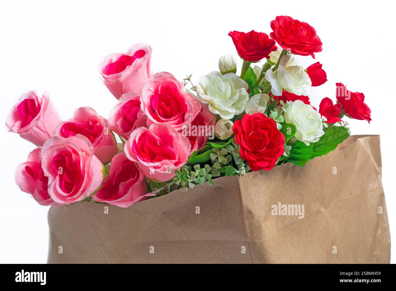 Un superbe bouquet de roses artificielles roses, rouges et blanches au feuillage luxuriant dans un sac en papier sur fond blanc, parfait pour la décoration, cadeau Banque D'Images