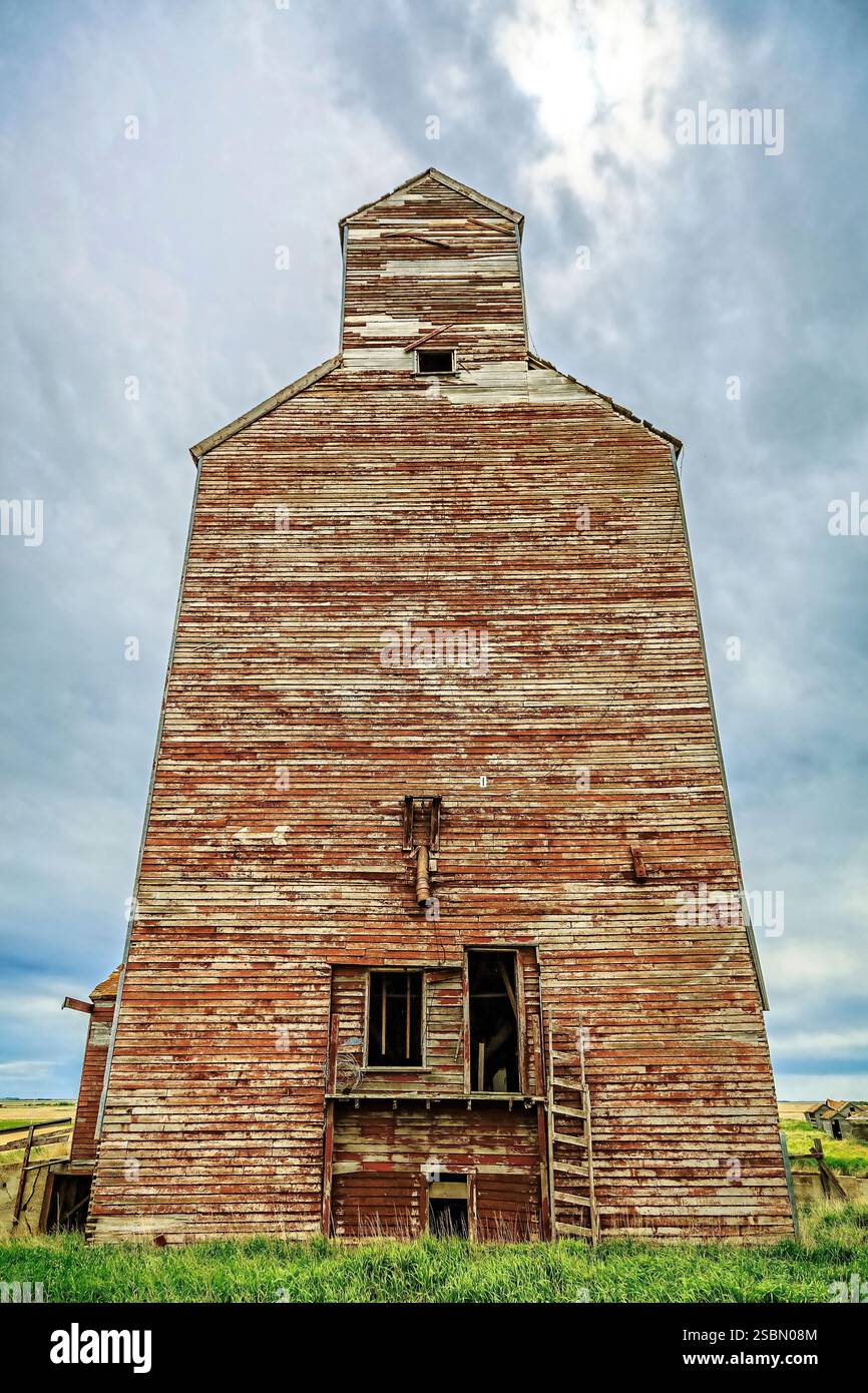 Grand bâtiment ancien en bois avec un toit rouge. Le bâtiment est vide et a beaucoup de bois dessus Banque D'Images