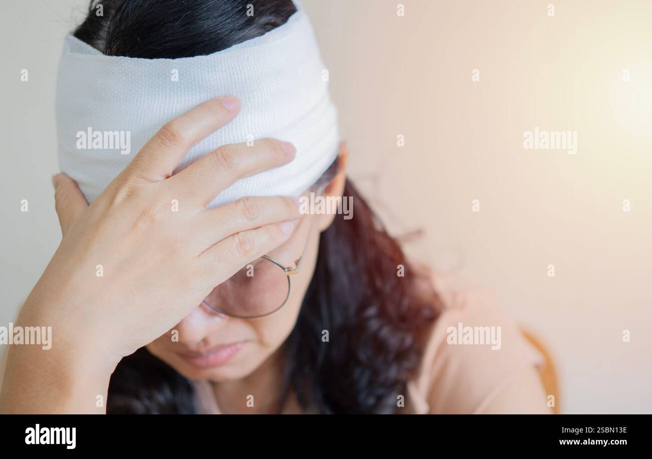 Plan d'une femme asiatique avec un traumatisme de la tête et des bandages enroulés autour de sa tête. Mise au point sélective, espace de copie. Banque D'Images