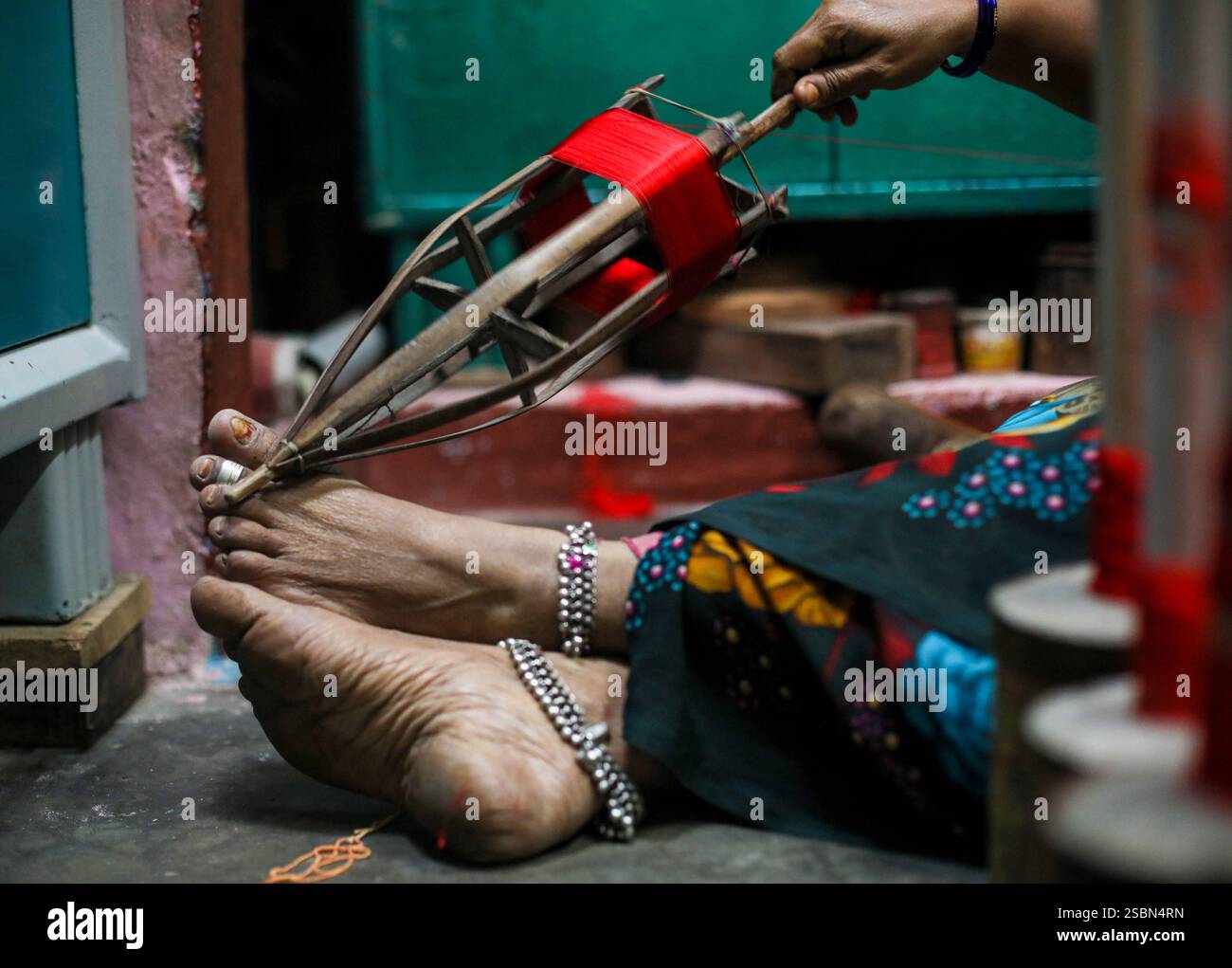 Kanchipuram Sari de l'Inde Un tisserand prépare les fils de soie pour le processus de tissage final, en s'assurant qu'ils sont mous et prêts à l'emploi pour fabriquer Kanchipuram Saris, à Kanchipuram, à environ 72 km de Chennai, en Inde, le 30 décembre 2024. Le Kanchipuram Sari, également connu sous le nom de Kanjeevaram Sari, est un Sari de soie traditionnel tissé à la main de la ville de Kanchipuram dans le Tamil Nadu, en Inde. Il est réputé pour ses designs complexes, ses couleurs vibrantes et son tissu en soie luxueux, ce qui en fait l'un des Saris les plus recherchés pour les mariages, les festivals et autres occasions spéciales. Les fabricants de sari Kanchipuram font face à plusieurs chal Banque D'Images
