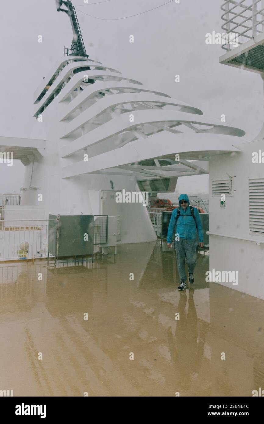 Homme sous la pluie sur le pont du ferry de Bari à Dubrovnik Banque D'Images