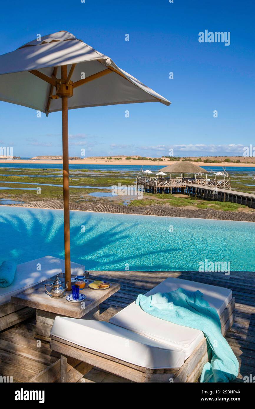 Maroc, province de Sidi Bennour, Oualidia, thé à la menthe et crêpes morrocanes dans un transat au bord de la piscine à débordement de l’hôtel de luxe la Sultana, face au lagon Banque D'Images