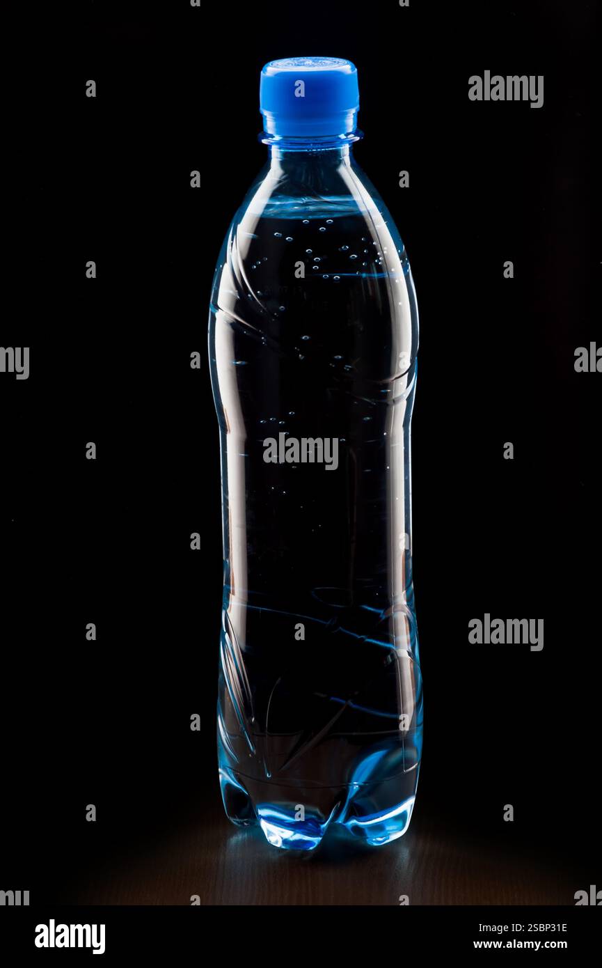 bouteille d'eau minérale sur un fond sombre Banque D'Images