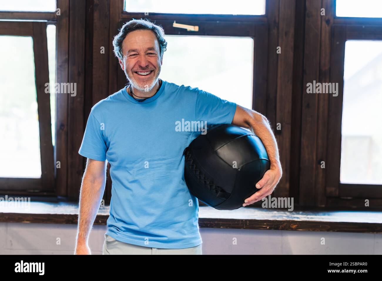 Un homme tient une boule noire dans sa main et souriant concept de bonheur et de positivité Banque D'Images