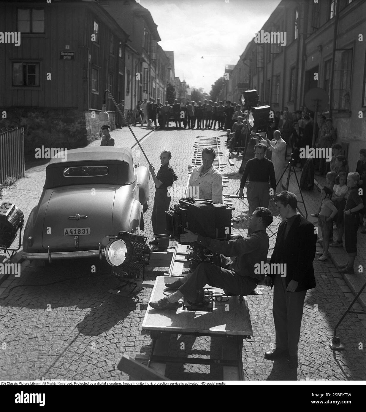 för min heta ungdoms crâne 1952. Film dramatique réalisé par Arne Mattsson. La photo montre le tournage à Uppsala. La caméra est montée sur une plate-forme mobile sur des rails qui suivent les acteurs et la voiture lorsqu'elle se déplace. Le film a été présenté en première suédoise le 17 décembre 1952 Banque D'Images