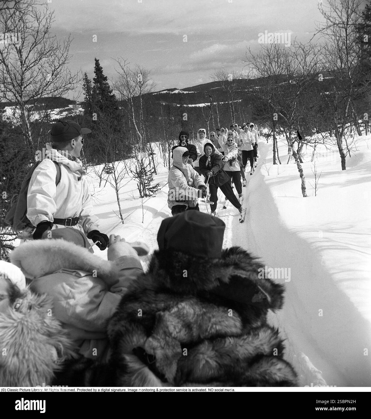 Åre 1952. La station de sports d'hiver populaire à Jämtland Suède où les gens vont skier et socialiser. Åre est connue pour sa longue histoire du ski et les années 1950 étaient une époque où le ski était une attraction sportive et touristique croissante. La photo montre des gens qui participent à des activités hivernales comme le ski derrière une motoneige, être remorqués à basse vitesse à travers la nature sauvage. Photographe : Svahn Banque D'Images