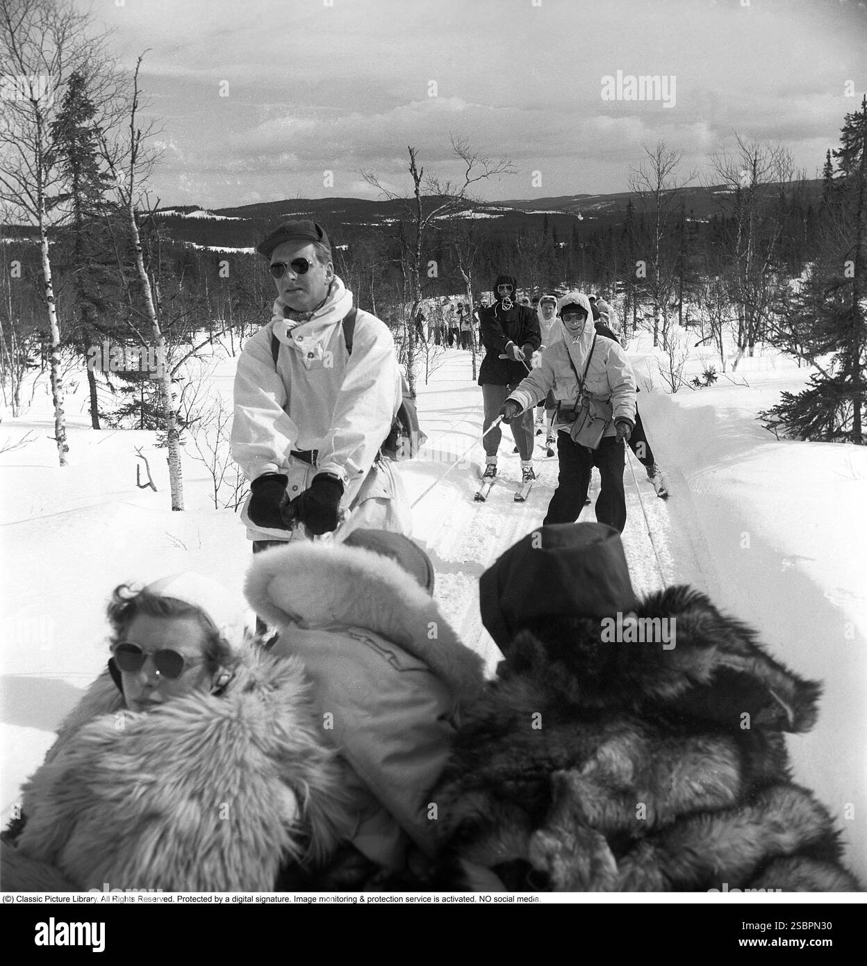 Åre 1952. La station de sports d'hiver populaire à Jämtland Suède où les gens vont skier et socialiser. Åre est connue pour sa longue histoire du ski et les années 1950 étaient une époque où le ski était une attraction sportive et touristique croissante. La photo montre des gens qui participent à des activités hivernales comme le ski derrière une motoneige, être remorqués à basse vitesse à travers la nature sauvage. Photographe : Svahn Banque D'Images
