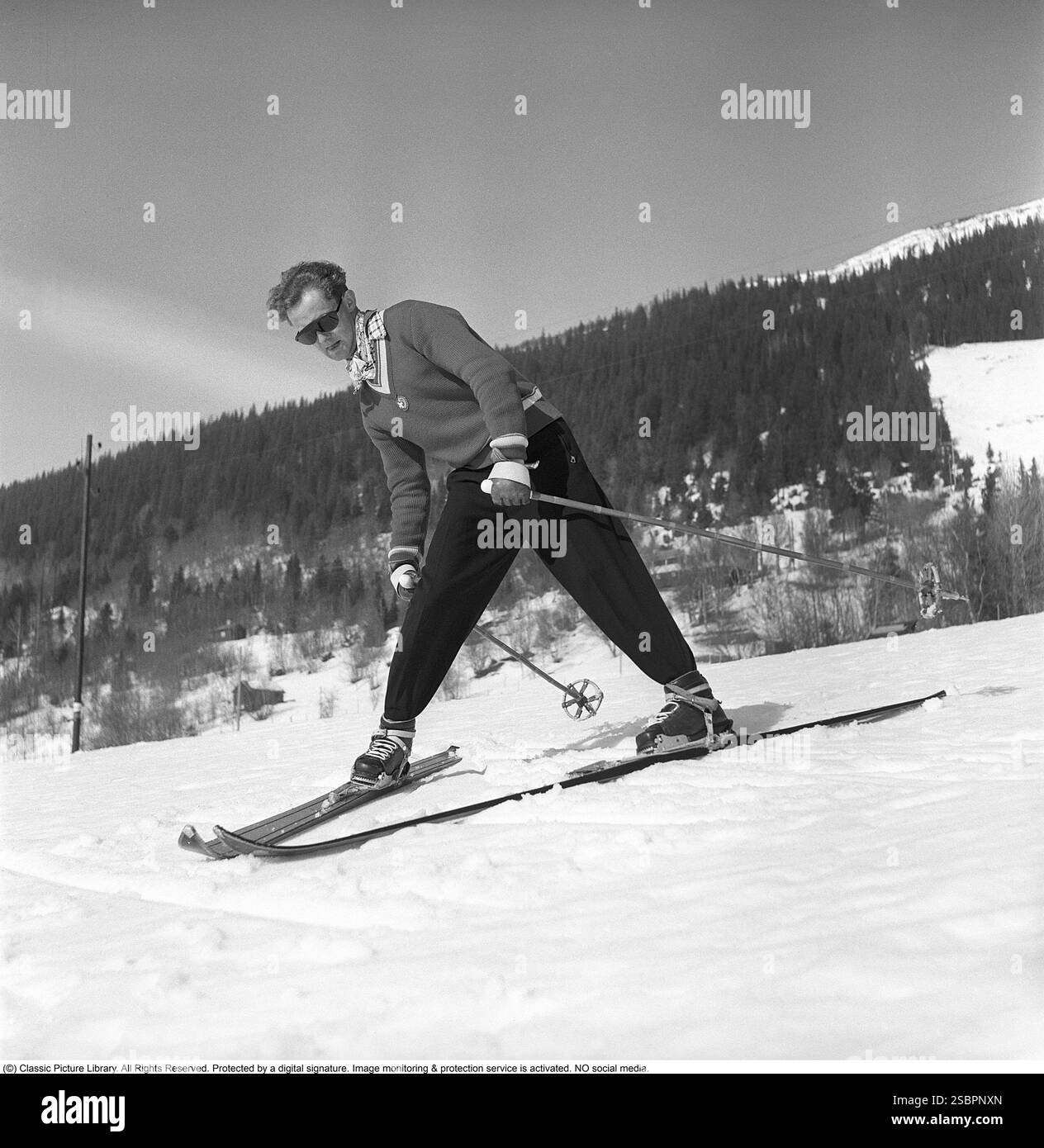 Åre 1952. La station de sports d'hiver populaire à Jämtland Suède où les gens vont skier et socialiser. Sur la photo est un homme qui pourrait être quelque chose d'un expert en ski alpin et slalom, démontrant la bonne façon de tourner et de skier sur la pente. Son équipement de ski, y compris les skis, les fixations et les bâtons, doit avoir été le plus moderne disponible à l'époque. Åre est connue pour sa longue histoire du ski et les années 1950 étaient une époque où le ski était une attraction sportive et touristique croissante. Photographe : Svahn Banque D'Images