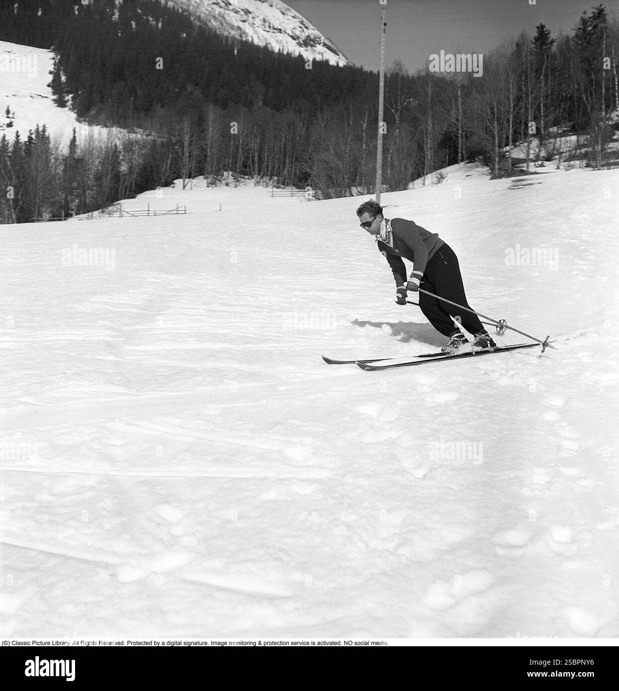 Åre 1952. La station de sports d'hiver populaire à Jämtland Suède où les gens vont skier et socialiser. Sur la photo est un homme qui pourrait être quelque chose d'un expert en ski alpin et slalom, démontrant la bonne façon de tourner et de skier sur la pente. Son équipement de ski, y compris les skis, les fixations et les bâtons, doit avoir été le plus moderne disponible à l'époque. Åre est connue pour sa longue histoire du ski et les années 1950 étaient une époque où le ski était une attraction sportive et touristique croissante. Photographe : Svahn Banque D'Images