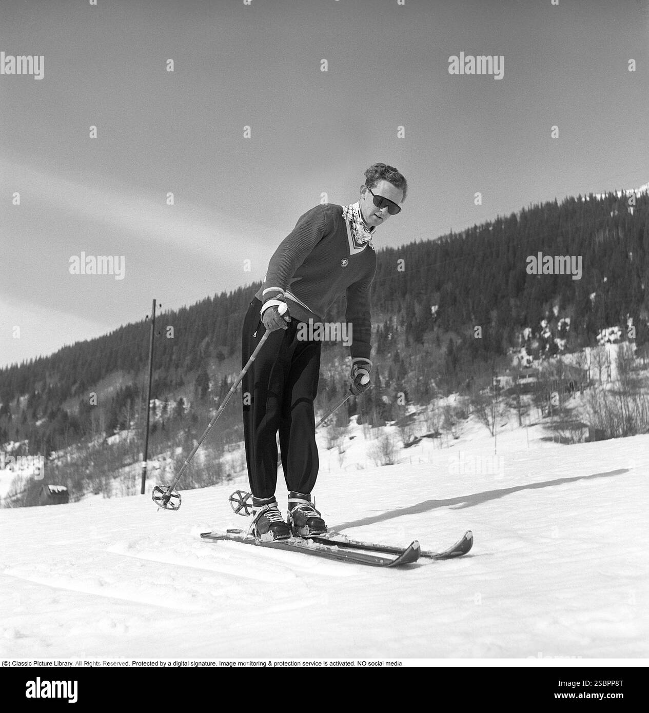 Åre 1952. La station de sports d'hiver populaire à Jämtland Suède où les gens vont skier et socialiser. Sur la photo est un homme qui pourrait être quelque chose d'un expert en ski alpin et slalom, démontrant la bonne façon de tourner et de skier sur la pente. Son équipement de ski, y compris les skis, les fixations et les bâtons, doit avoir été le plus moderne disponible à l'époque. Åre est connue pour sa longue histoire du ski et les années 1950 étaient une époque où le ski était une attraction sportive et touristique croissante. Photographe : Svahn Banque D'Images