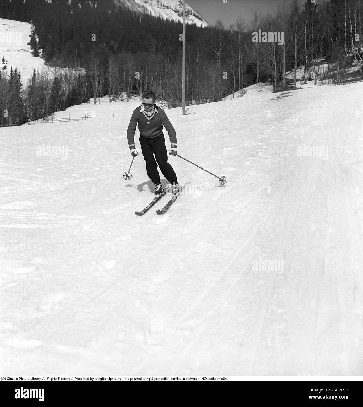 Åre 1952. La station de sports d'hiver populaire à Jämtland Suède où les gens vont skier et socialiser. Sur la photo est un homme qui pourrait être quelque chose d'un expert en ski alpin et slalom, démontrant la bonne façon de tourner et de skier sur la pente. Son équipement de ski, y compris les skis, les fixations et les bâtons, doit avoir été le plus moderne disponible à l'époque. Åre est connue pour sa longue histoire du ski et les années 1950 étaient une époque où le ski était une attraction sportive et touristique croissante. Photographe : Svahn Banque D'Images