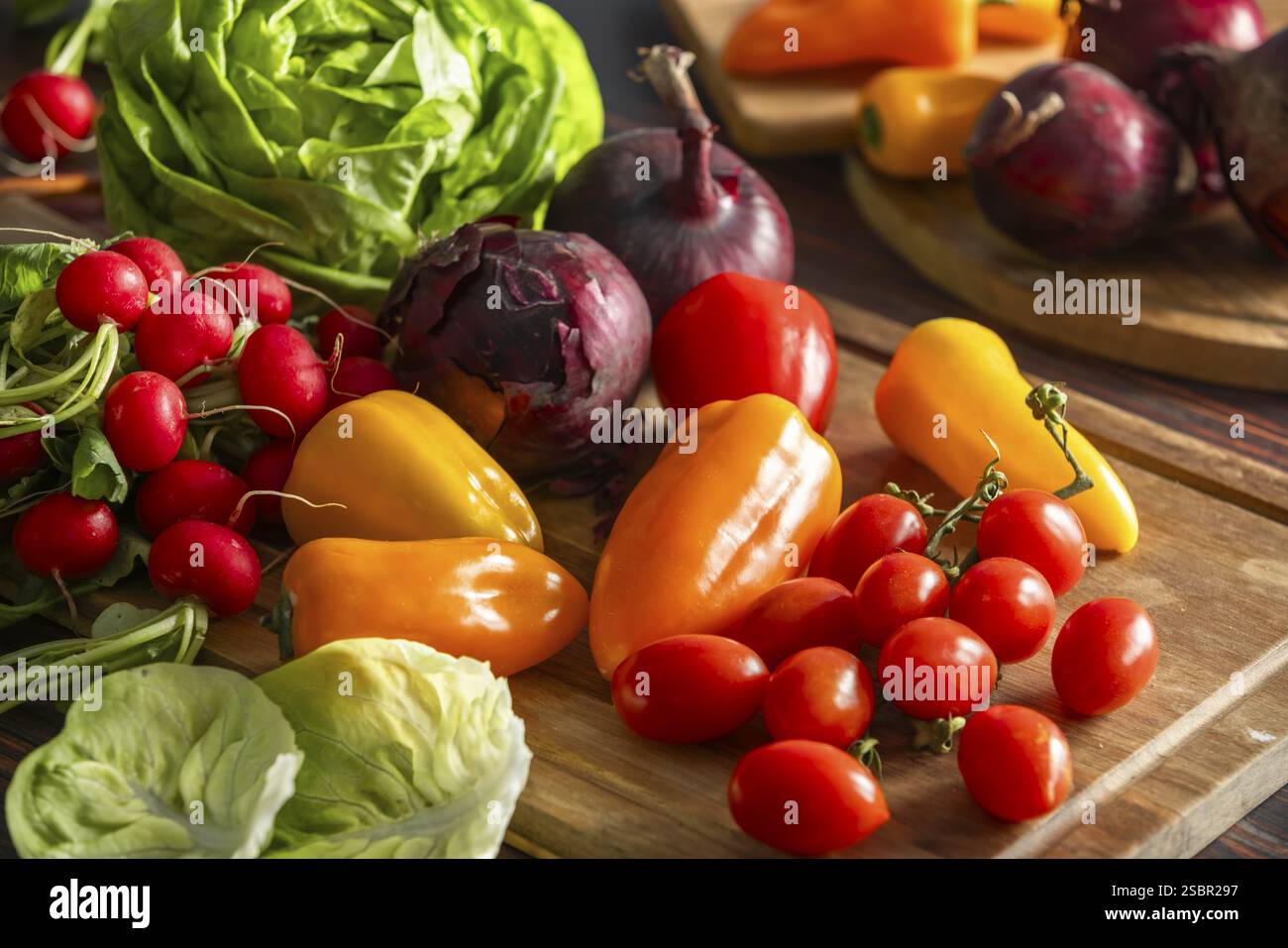 Un arrangement de légumes frais tels que les poivrons, les radis, la laitue et les tomates Banque D'Images