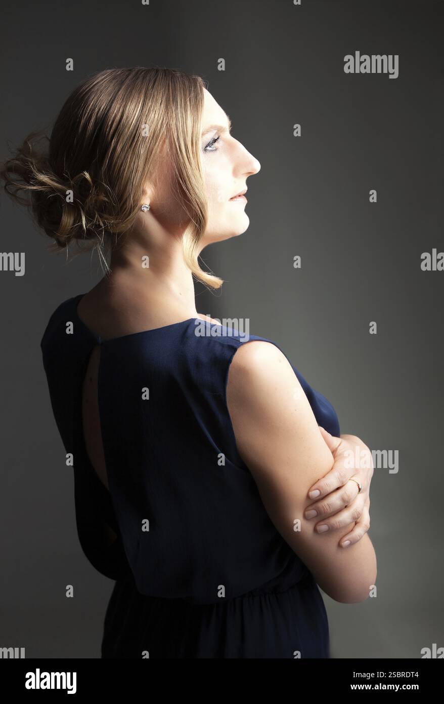 Portrait d'une femme aux cheveux blonds parfaits et maquillage. Sur fond gris Banque D'Images