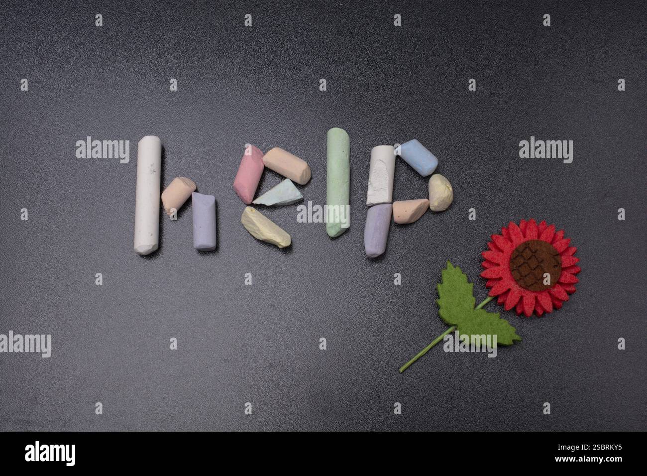 Mot d'aide écrit à la craie incolorée sur un tableau noir Banque D'Images