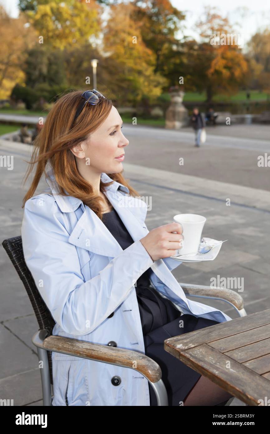 Femme d'affaires adulte utilisant la tablette sur la pause déjeuner dans le parc de la ville Banque D'Images
