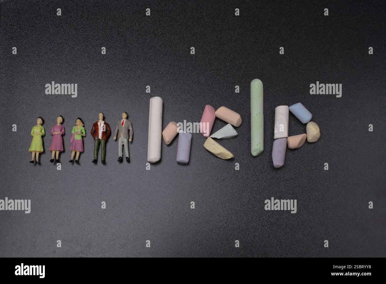 Mot d'aide écrit à la craie incolorée sur un tableau noir Banque D'Images