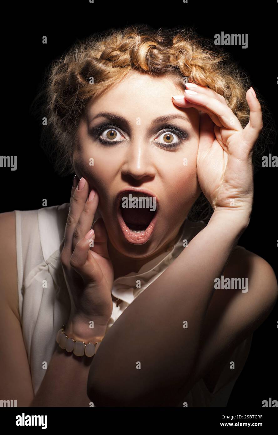Visage d'une jeune femme blonde choquée Banque D'Images