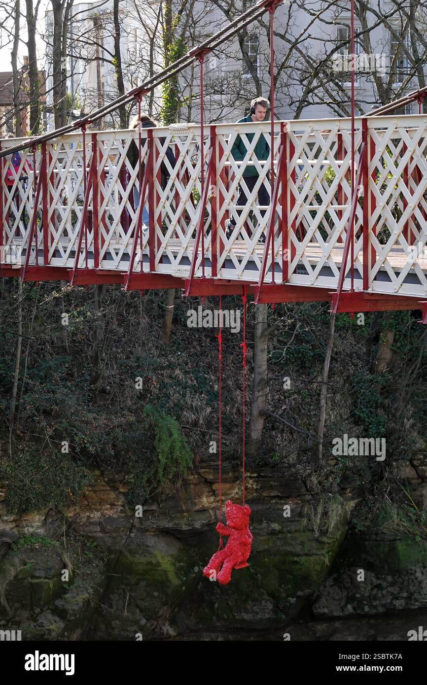 Bristol, Royaume-Uni. Une sculpture d'ours en peluche rouge de l'artiste français James Colomina suspendue sous le pont Gaol Ferry, Bristol. Banque D'Images