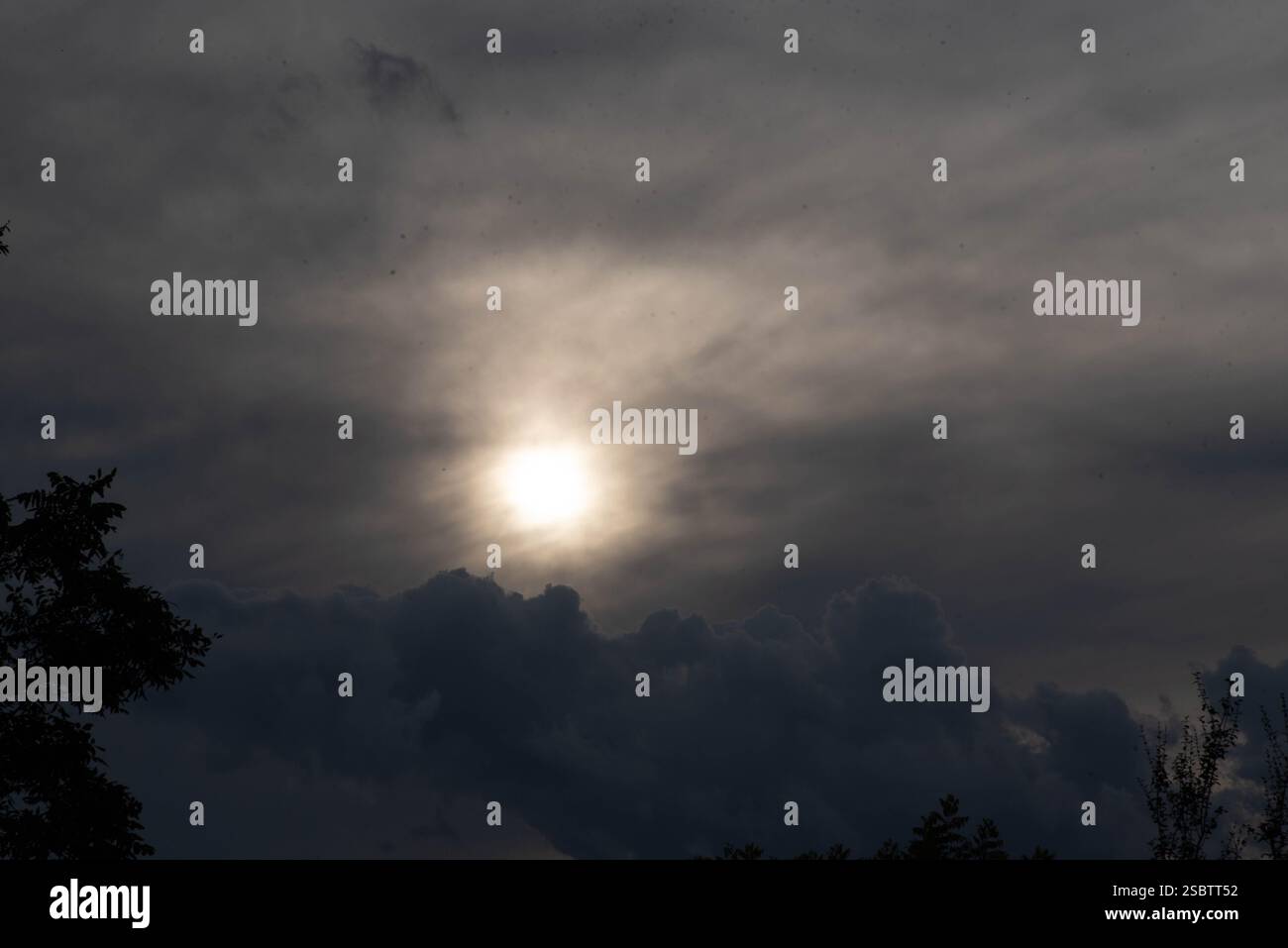 Nuages de pluie contrastant avec le soleil en fin de journée.. Banque D'Images