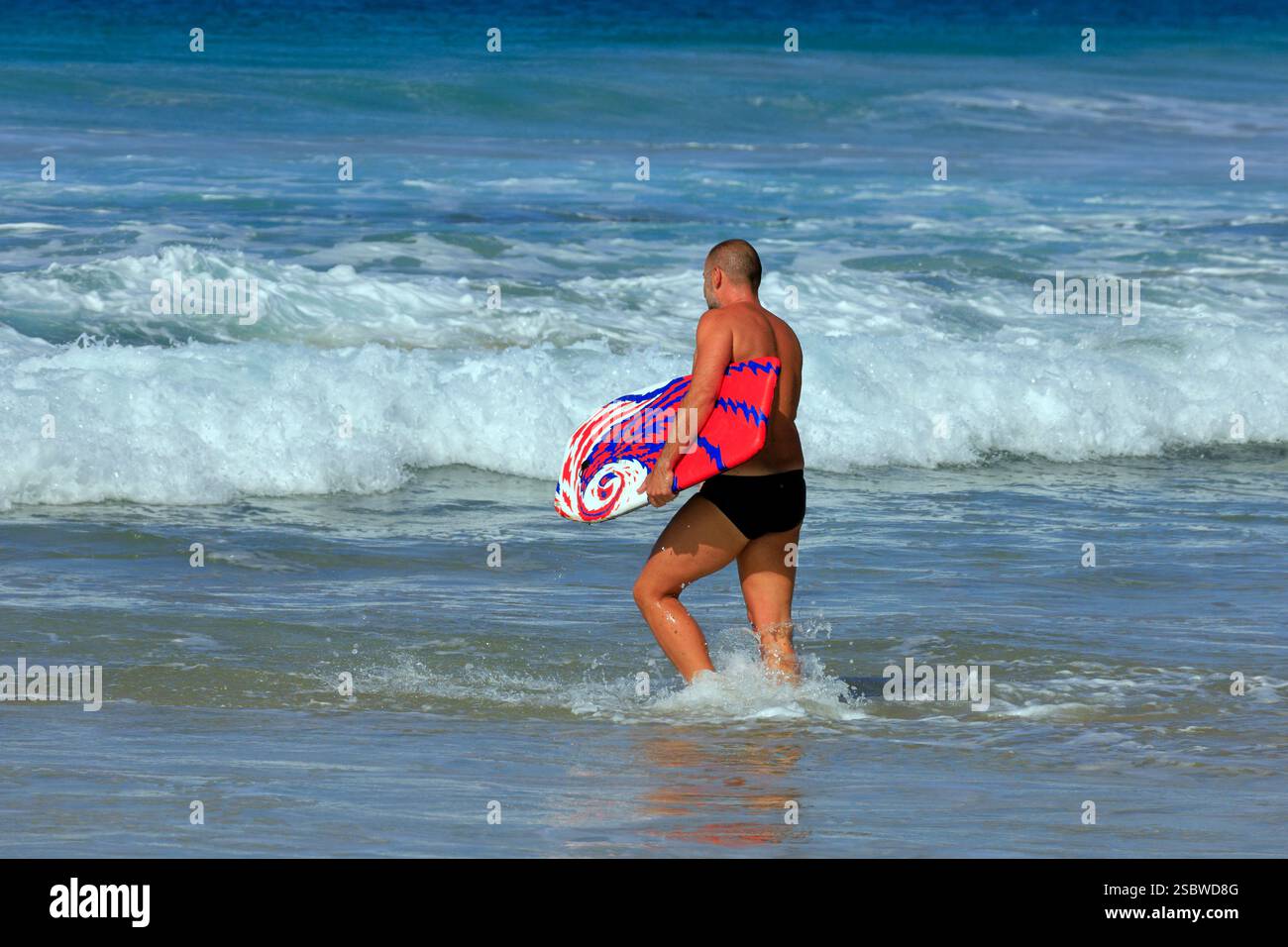 Corps frontière marcher dans la mer à Piedra Playa plage, El Cotillo, Fuerteventura, îles Canaries, Espagne. Prise en novembre 2024 Banque D'Images