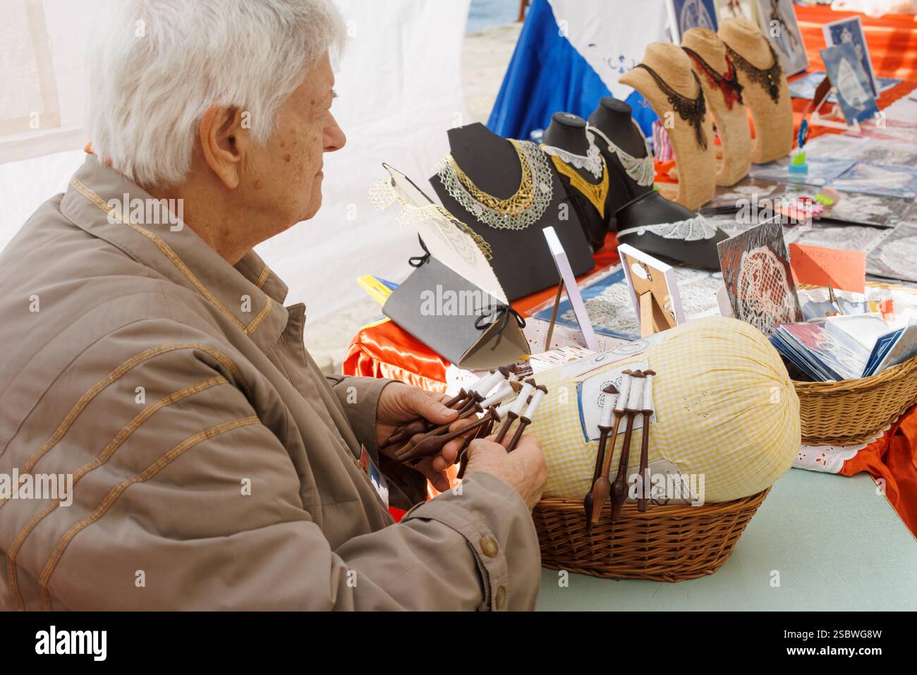 Trieste, Italie - 13 octobre 2024 : artisan travaillant sur la dentelle de bobine, modelé par Irma Pervanja. École de Merletti di Idrija Banque D'Images Trieste, Italie - 13 octobre 2024 : artisan travaillant sur la dentelle de bobine, modelé par Irma Pervanja. École de Merletti di Idrija Banque D'Images
