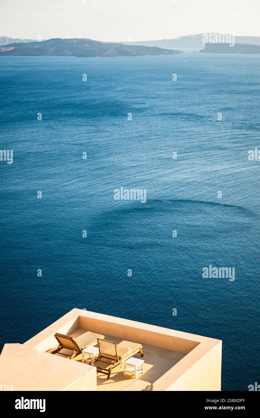 Deux chaises longues vides sur une terrasse en face de la mer dans la caldeira de Santorin, Cyclades, Griencehnland Banque D'Images