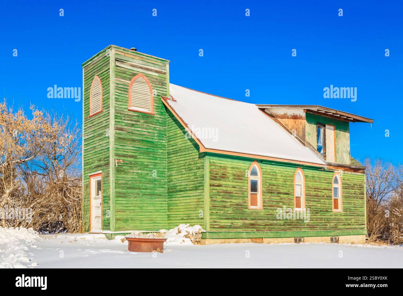 Église verte avec un toit couvert de neige. Le toit est incliné et le bâtiment est vieux Banque D'Images