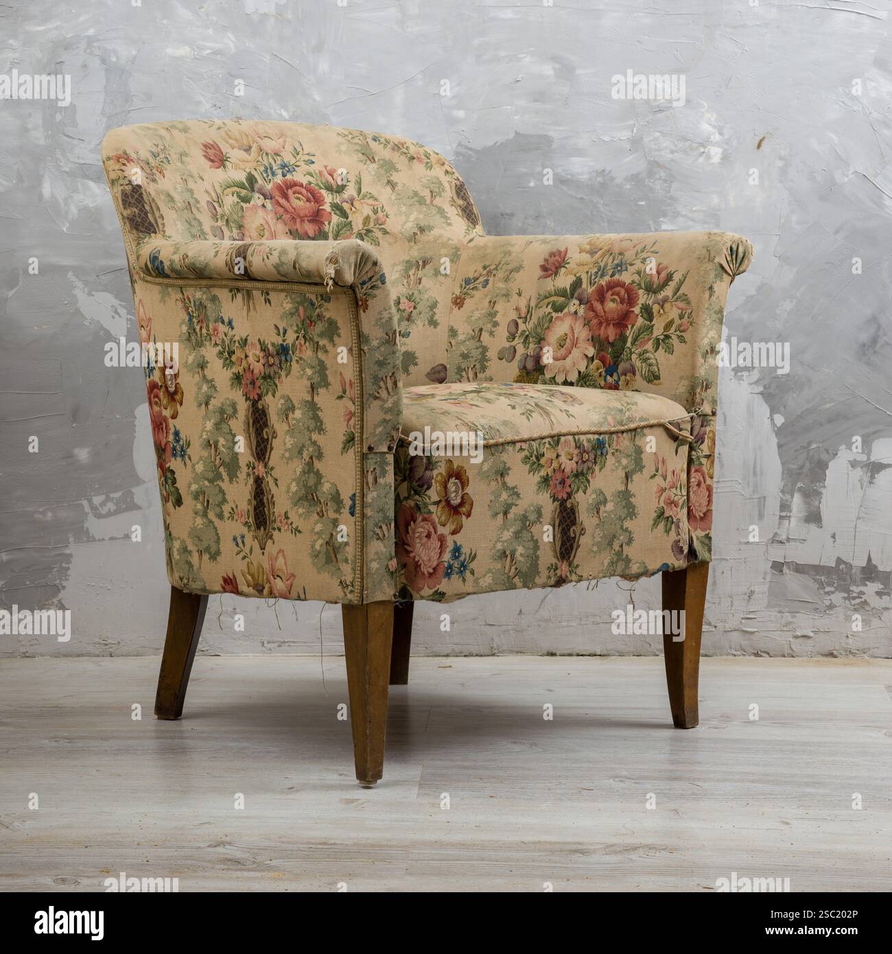 Fauteuil vintage ou antique avec un motif floral. Charmant meuble légèrement usé. Parfait pour vintage, antique, design d'intérieur, ou furni Banque D'Images