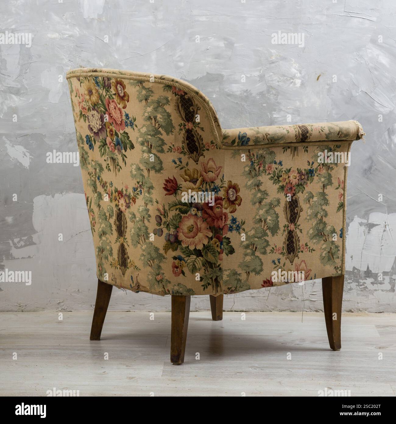 Fauteuil vintage ou antique avec un motif floral. Charmant meuble légèrement usé. Parfait pour vintage, antique, design d'intérieur, ou furni Banque D'Images