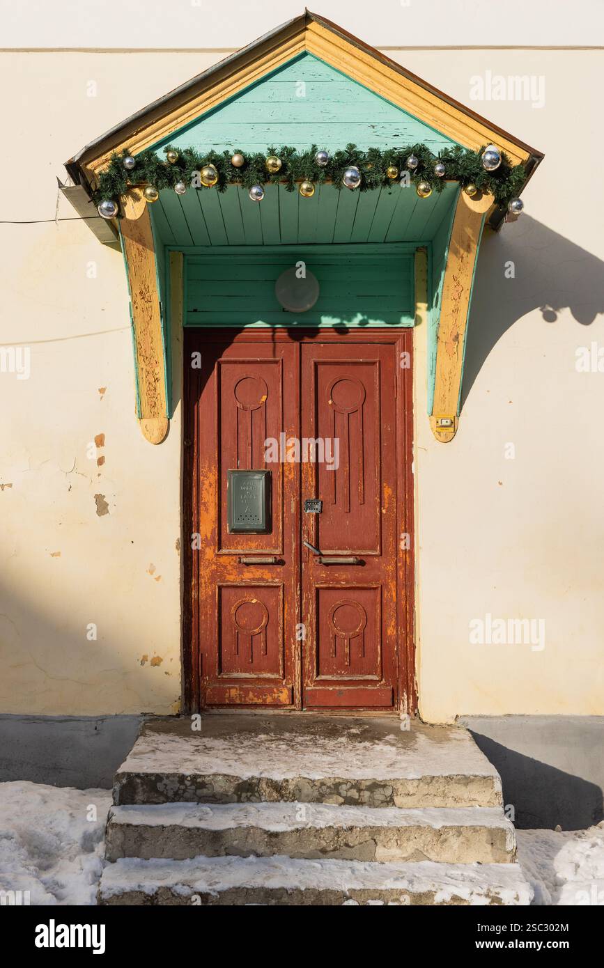 Porte en bois brun vintage avec serrure de code est sous la verrière dans le mur jaune. Ancienne architecture classique, texture de fond verticale, vue de face. Russe te Banque D'Images