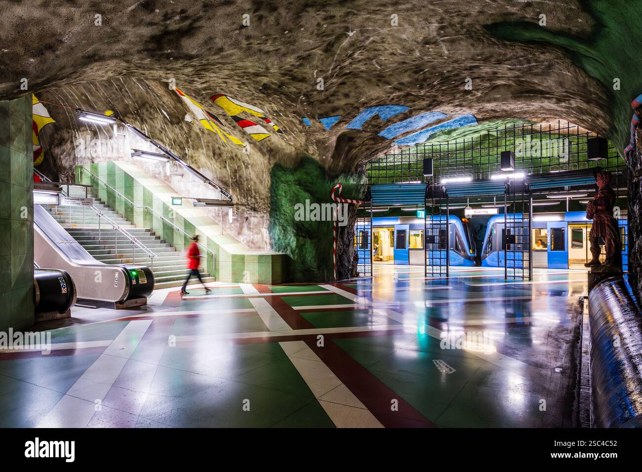 Un train de métro C20 se trouve au quai de la gare de Kungsträdgården à Stockholm, en Suède, dont les couloirs ont été décorés par Ulrik Samuelson. Banque D'Images
