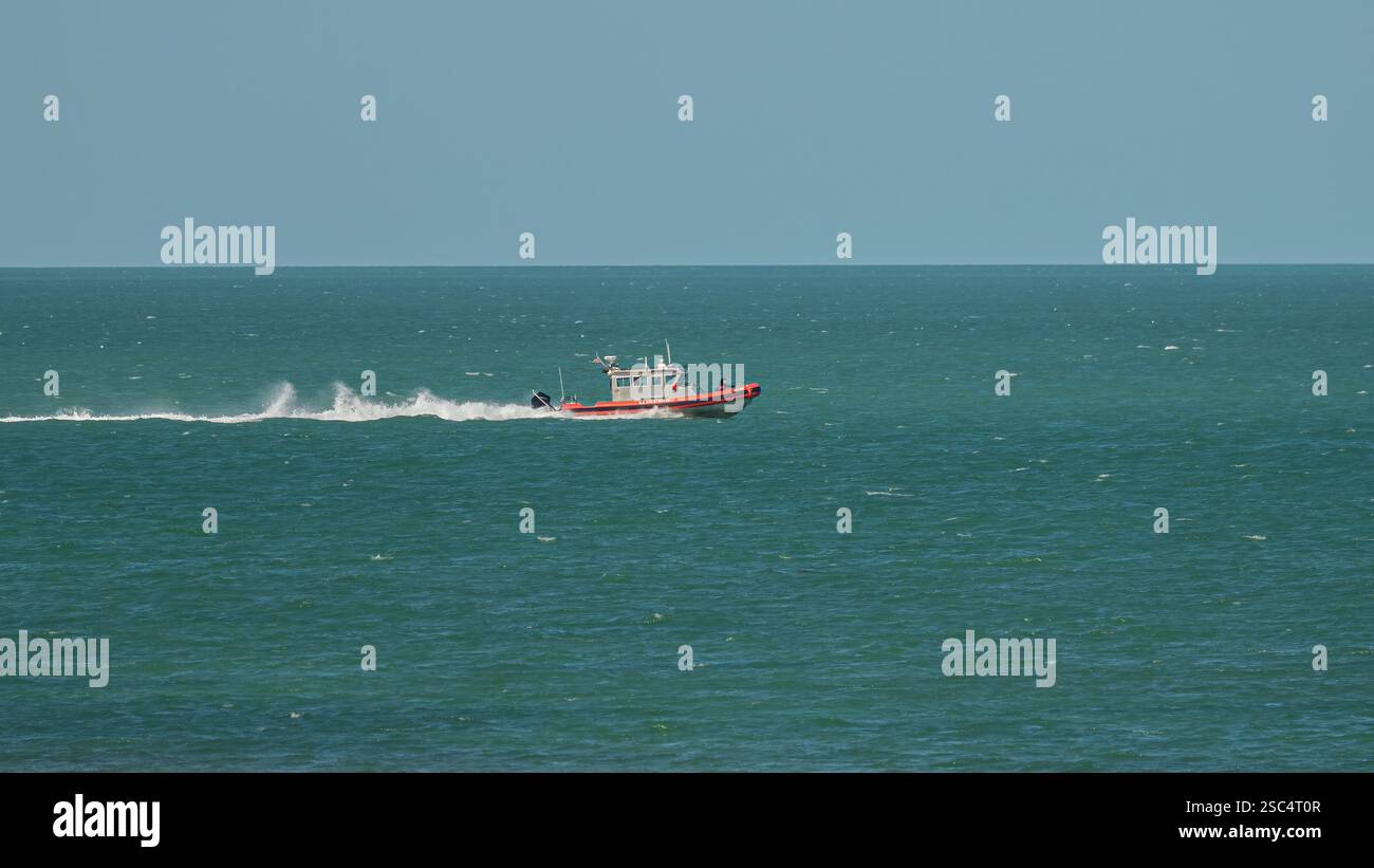 Un membre d'équipage pointe comme un engin spécial de la Garde côtière des États-Unis (application de la loi) se déplace à grande vitesse sur le golfe du Mexique, dans l'océan Atlantique Banque D'Images