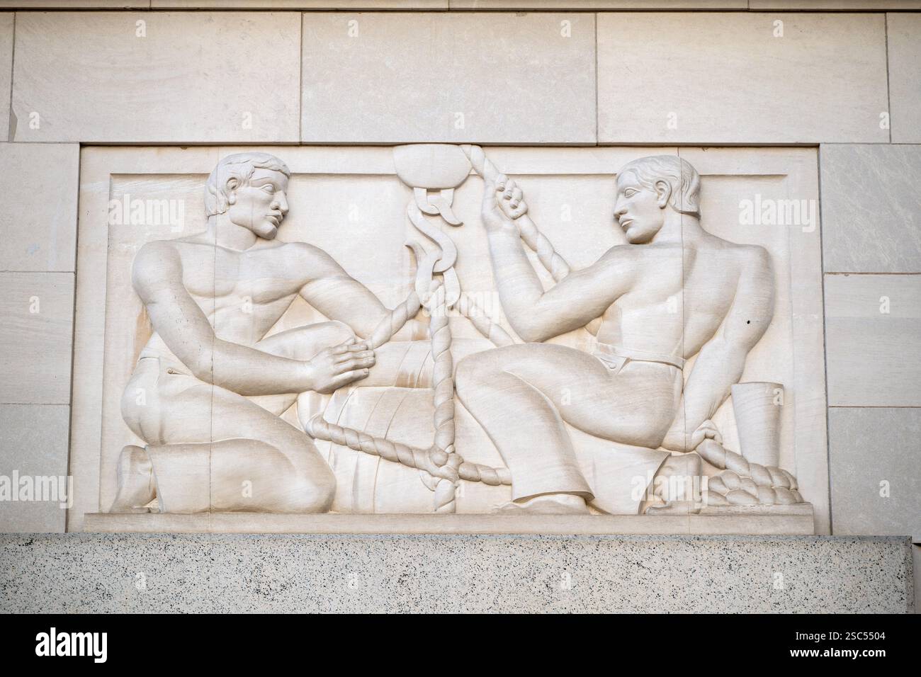 WASHINGTON DC — « Shipping », un bas-relief calcaire de Robert Laurent achevé en 1938, orne l'entrée de Pennsylvania Avenue du bâtiment de la Federal Trade Commission. Le panneau Art déco représente deux marins hissant une cargaison avec des poulies sur un navire, faisant partie d'une série illustrant différentes formes de commerce décorant les entrées du bâtiment. Banque D'Images