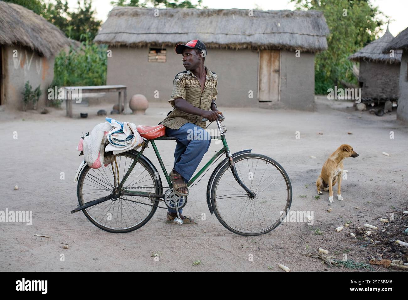 VILLAGE de MAKEFU, DIVISION IDODI, TANZANIE OCCIDENTALE, mai 2008 : un villageois qui rentre chez lui sur son vélo attend un ami. Ther vélo est la principale forme de transport pour tous les bons dans et hors du village. Banque D'Images
