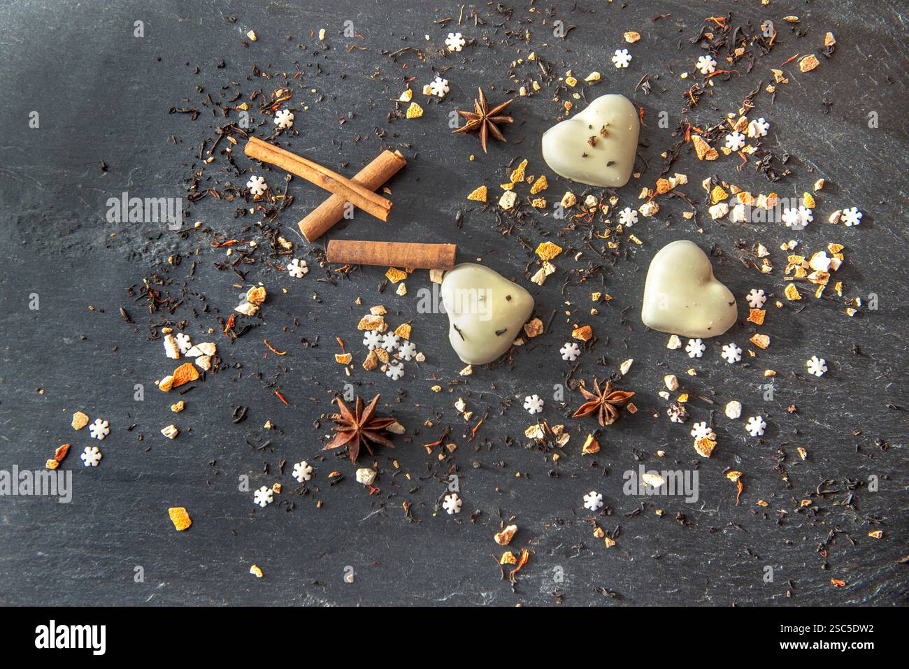 Biscuits en forme de coeur et épices disposés sur un fond d'ardoise grise Banque D'Images