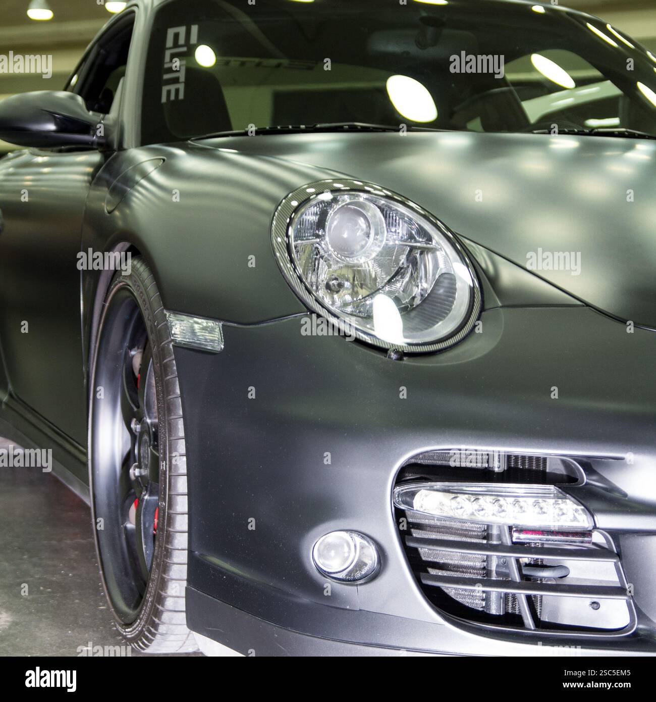 Une vue rapprochée d'une Porsche 911 gris foncé ou noir (probablement une génération 997). La voiture est à un salon automobile. Banque D'Images