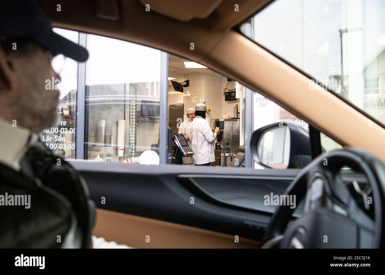 Employé de la restauration rapide et client lors d'une transaction au drive. Banque D'Images
