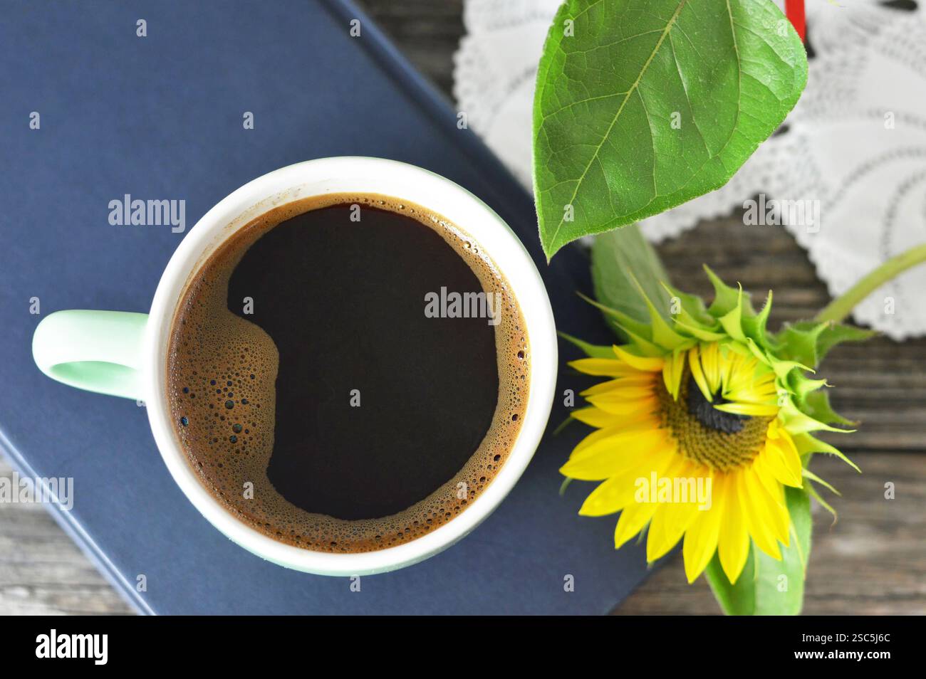 Vue de dessus de tasse de café, livre et tournesol Banque D'Images