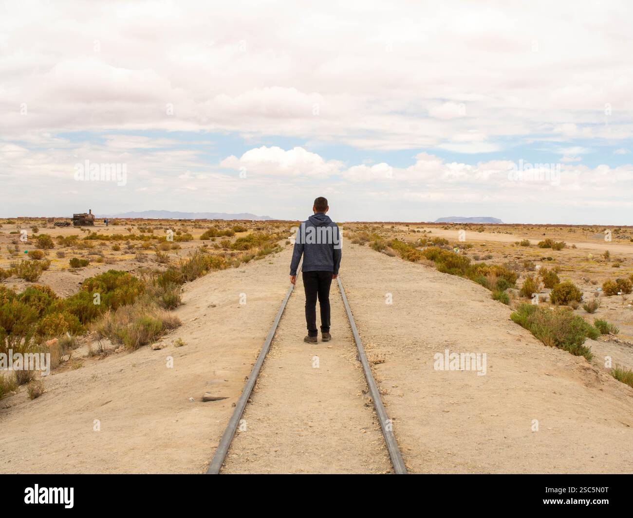 Voyageur marchant sur un chemin de fer abandonné à Uyuni Bolivie Banque D'Images