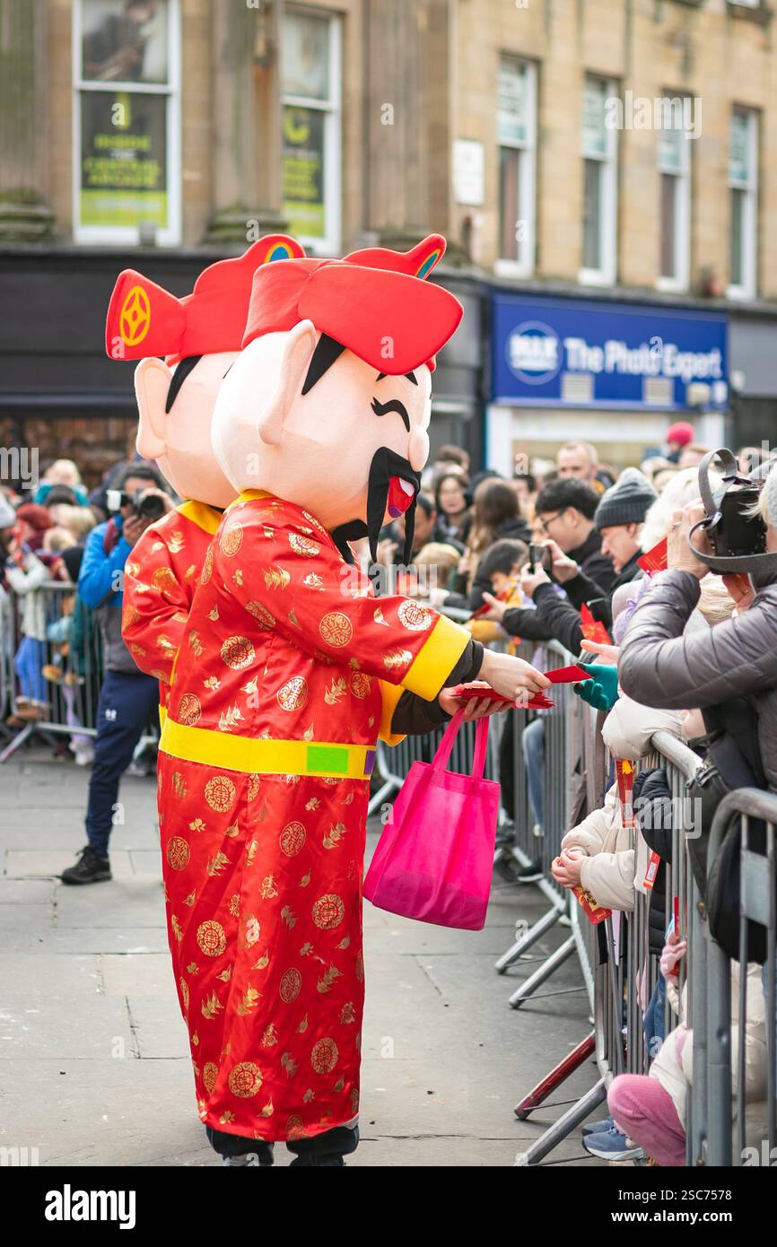 god of Prosperity fortune distribue des enveloppes rouges ou hongbau à la fille au défilé du nouvel an chinois CNY 2025 à Newcastle upon tyne uk année du serpent Banque D'Images