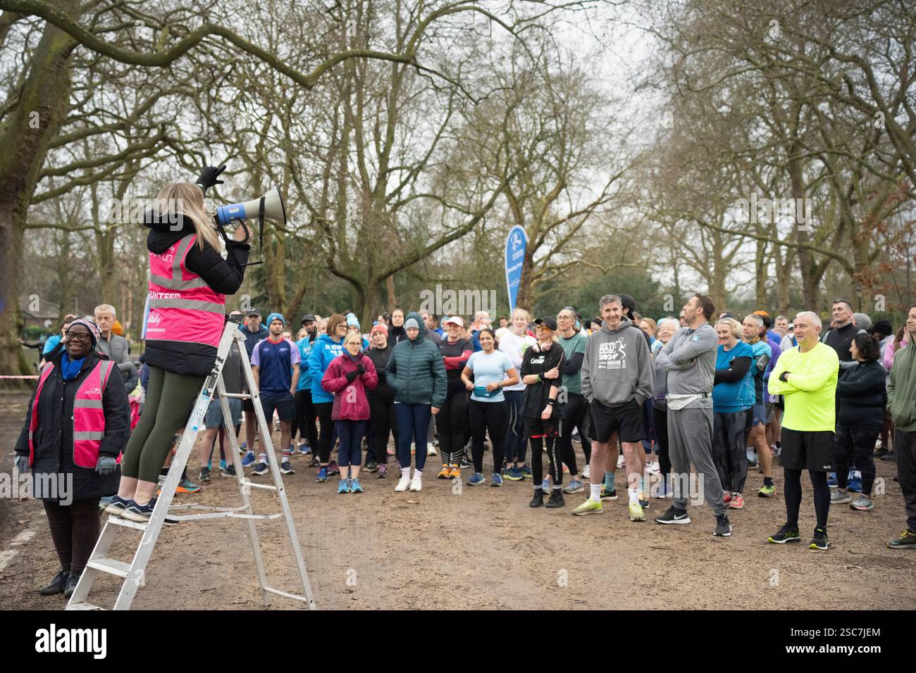 Coureurs au départ d'une course à Battersea Park, Londres. Les volontaires dirigent les coureurs. Banque D'Images