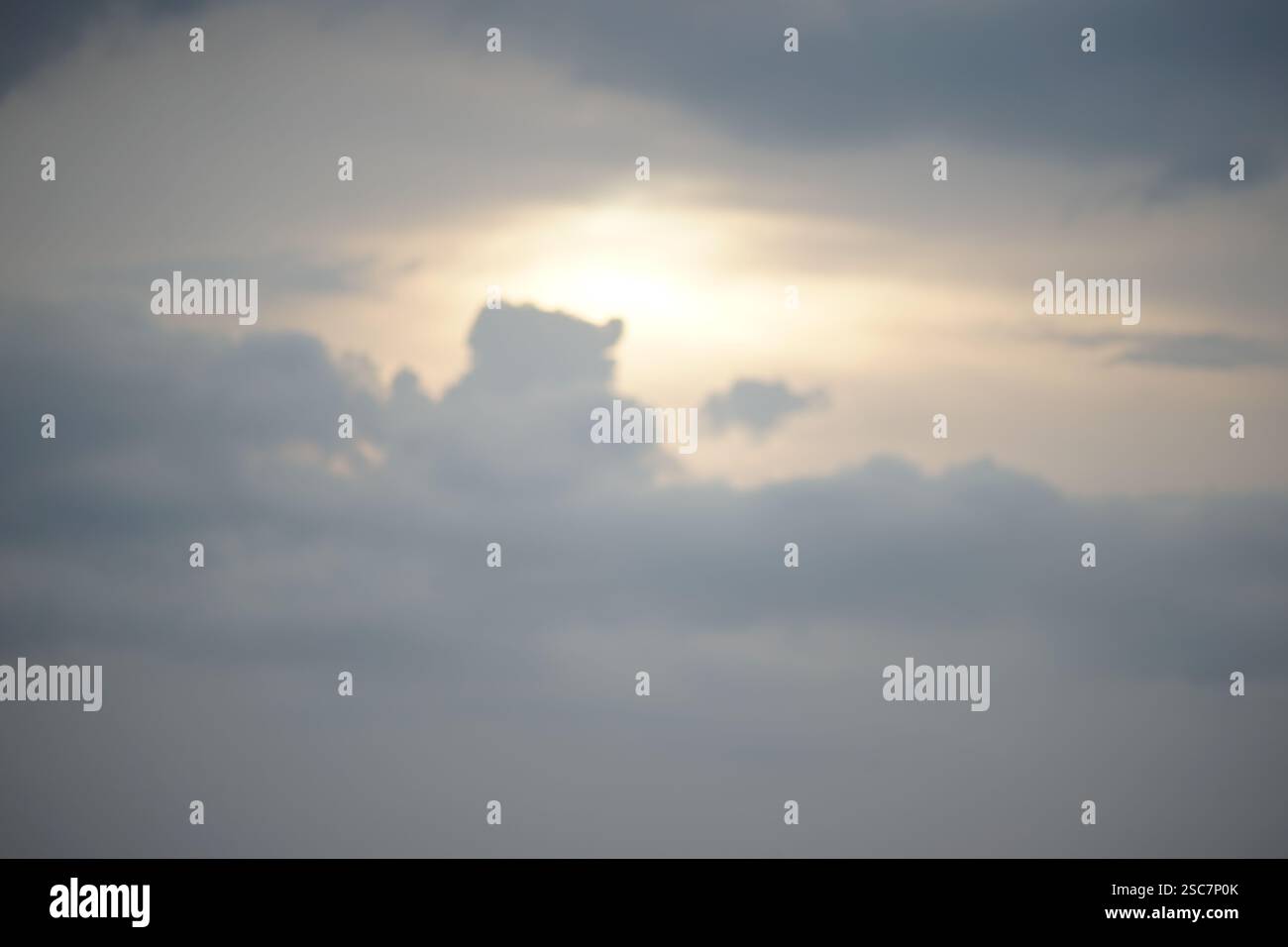 Nuages bleus avec le soleil caché derrière eux Banque D'Images