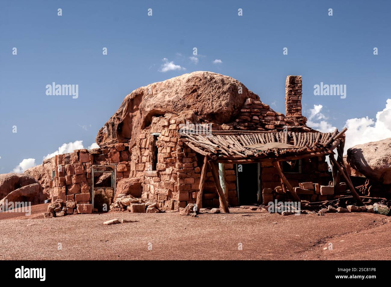 Une petite maison en pierre se trouve sur une colline rocheuse. Le toit est en bois et la maison est entourée d'une zone de terre Banque D'Images