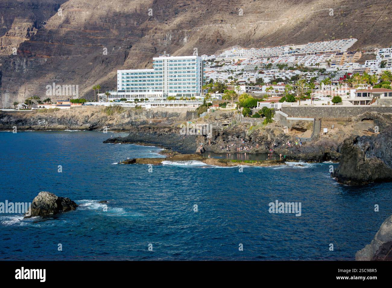 Los Gigantes, Santa Cruz de Tenerife, Espagne-01FEB2025-les gens nagent et s'amusent dans la piscine naturelle de roche de lave appelée Charco de Isla Cangrejo. Banque D'Images
